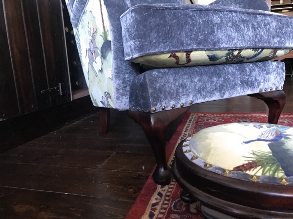 Leg and footstool detail of patterned velvet upholstery